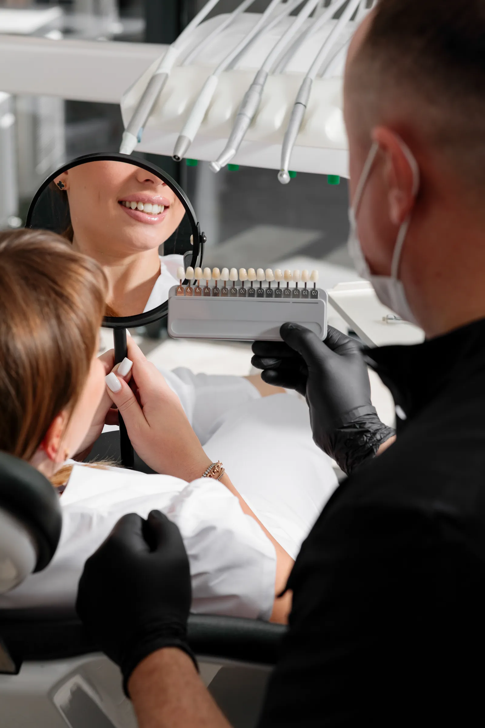 Dentist matching veneer shade during a consultation