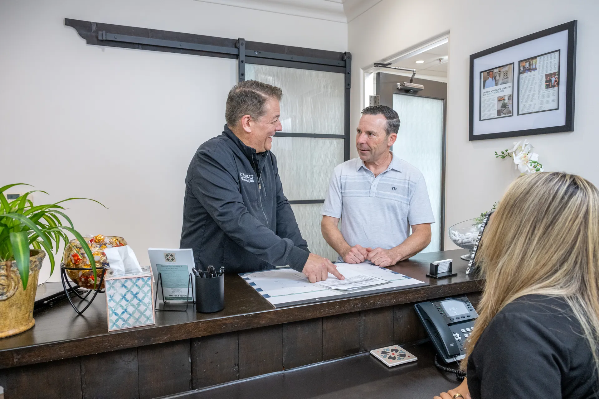 Dr. Shawn Hlavaty and a patient at the Hlavaty Dental Arts front desk